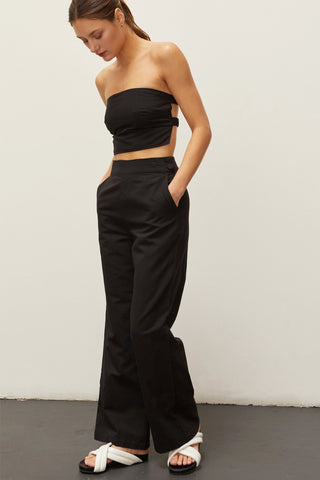A woman wearing a black linen bandeau two piece set.