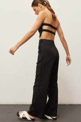 A woman wearing a black linen bandeau two piece set.