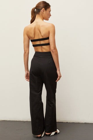 A woman wearing a black linen bandeau two piece set.