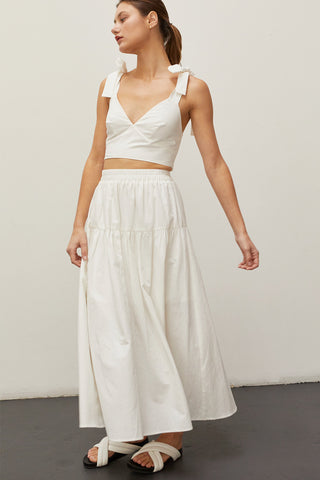 A woman wearing an ivory bow tie top two piece set.