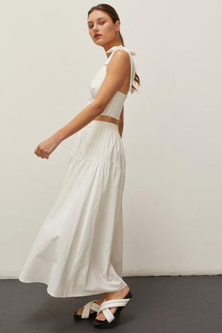 A woman wearing an ivory bow tie top two piece set.