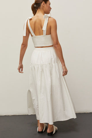 A woman wearing an ivory bow tie top two piece set.