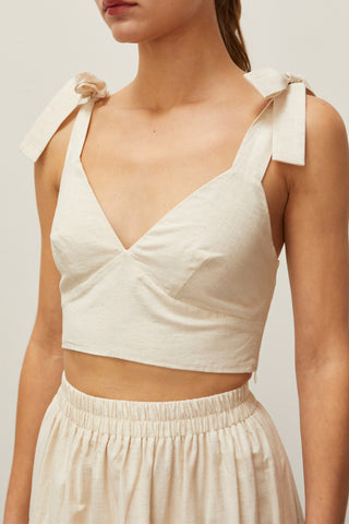 A woman wearing an oatmeal bow tie top two piece set.