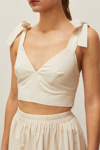 A woman wearing an oatmeal bow tie top two piece set.
