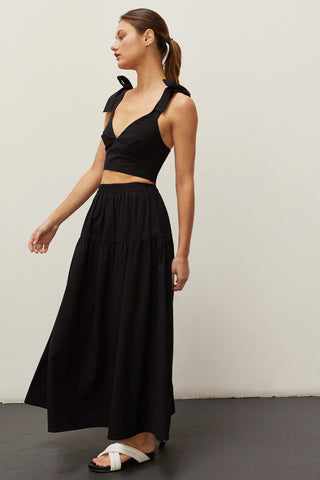 A woman wearing a black bow tie top two piece set.