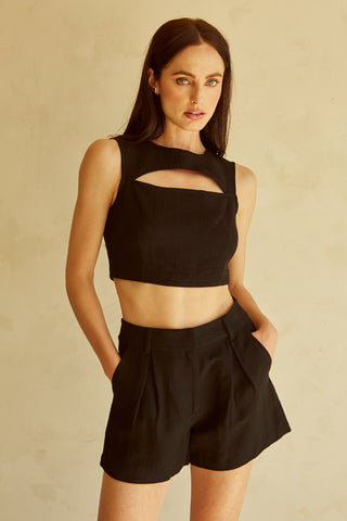A woman wearing a black cut-out sleeveless top set.