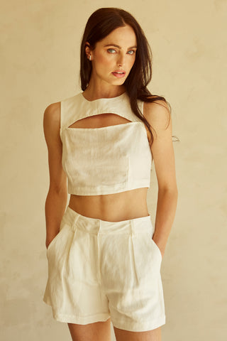 A woman wearing an ivory cut-out sleeveless top set.
