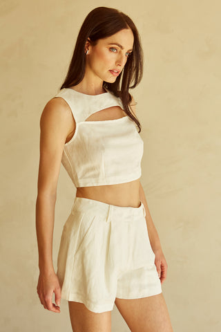 A woman wearing an ivory cut-out sleeveless top set.