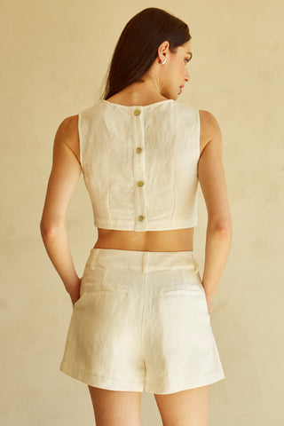 A woman wearing an ivory cut-out sleeveless top set.