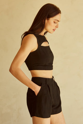 A woman wearing a black cut-out sleeveless top set.