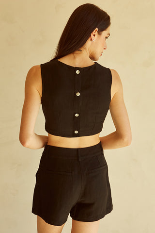 A woman wearing a black cut-out sleeveless top set.