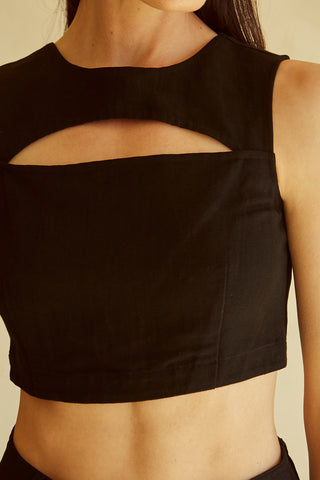 A woman wearing a black cut-out sleeveless top set.