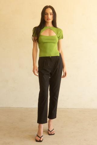 A woman wearing a fern short sleeve knit top with cut out detail at front chest.