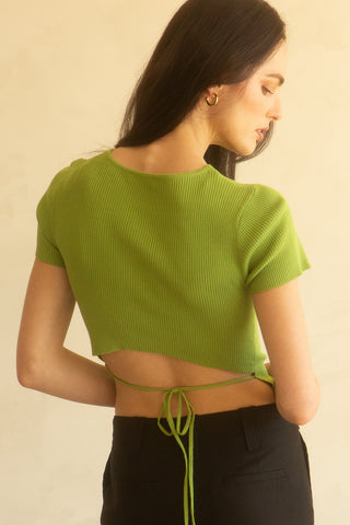 A woman wearing a fern short sleeve knit top with cut out detail at front chest.