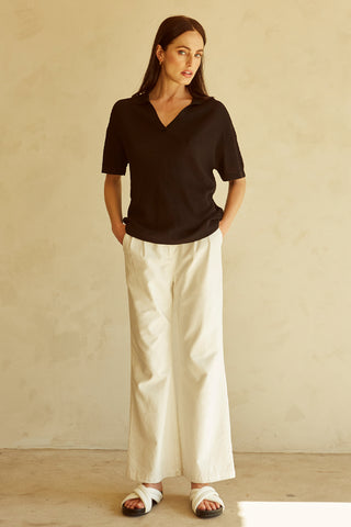 A woman wearing a black polo sweater top.