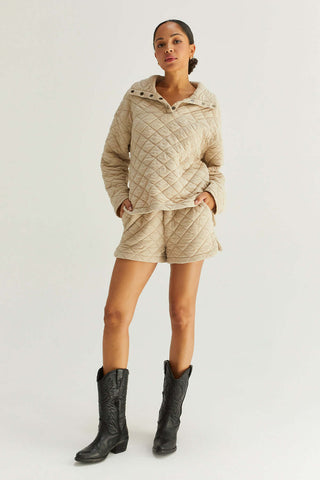 model wearing a beige oversized quilted sweater