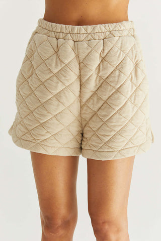 model wearing beige quilted high-waist shorts