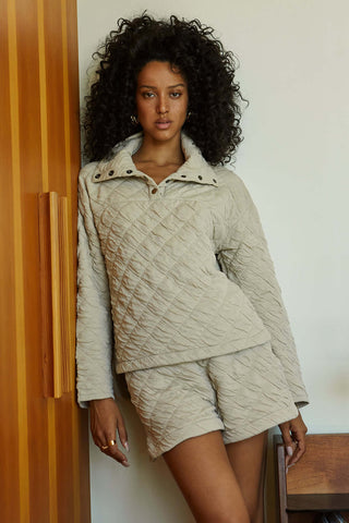 model wearing a beige quilted snap sweater