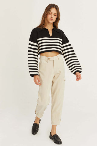 model wearing beige utility pants with loafers and sweater