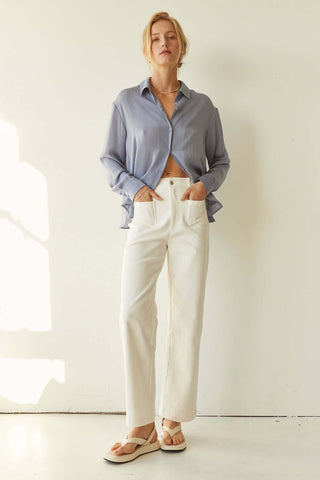 model wearing a blue blouse with white pants