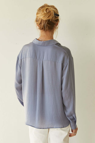 model wearing a blue collared satin blouse