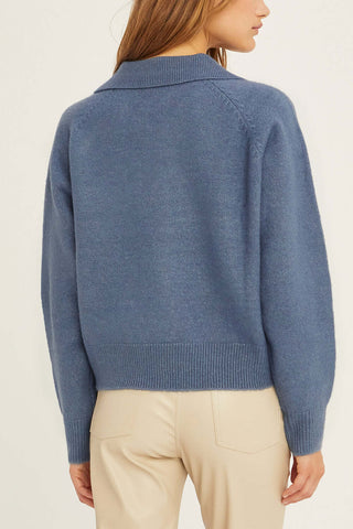 model wearing a blue collared sweater