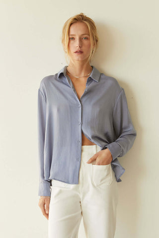 model wearing a blue satin button-up blouse