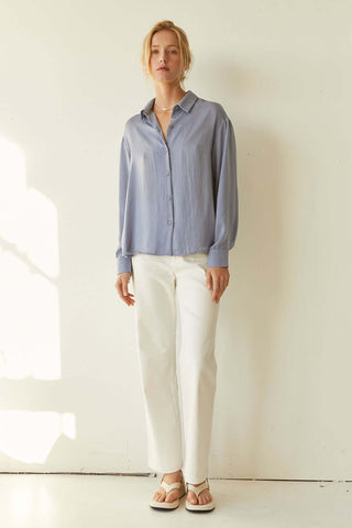 model wearing a blue satin long sleeve shirt