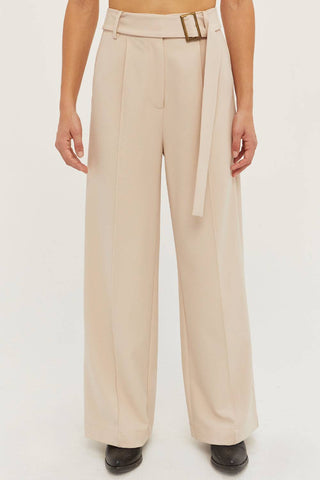 model wearing high-waisted cream pants with belt