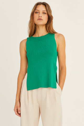 model wearing a green sleeveless sweater top
