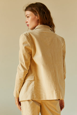 model posing in beige corduroy blazer