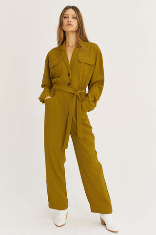 model wearing an olive belt-waist jumpsuit