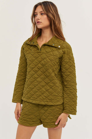 model wearing an olive quilted snap pullover