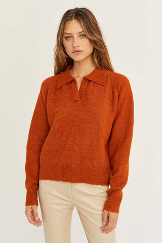model wearing a rust sweater and beige pants