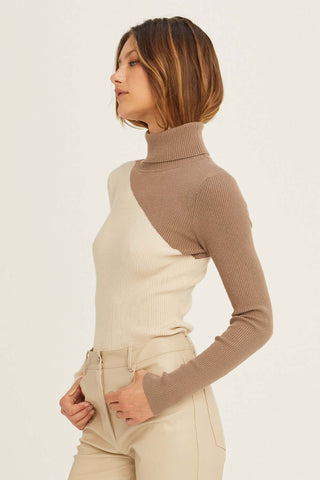 model wearing a turtleneck sweater with white jeans