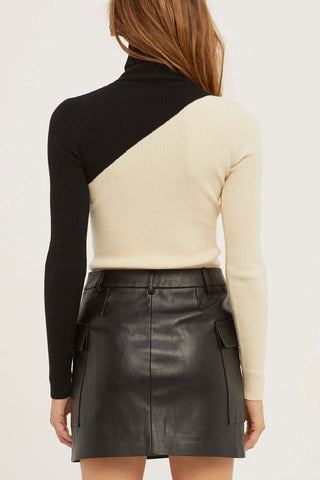model wearing a two-tone sweater with leather